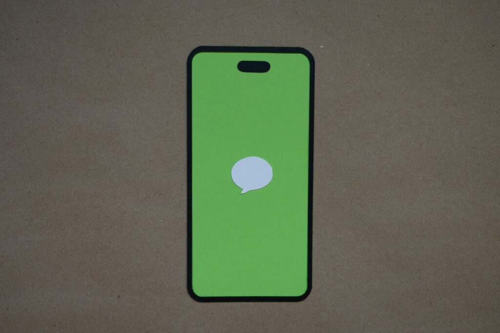 Teléfono móvil con una burbuja de mensaje en pantalla verde
