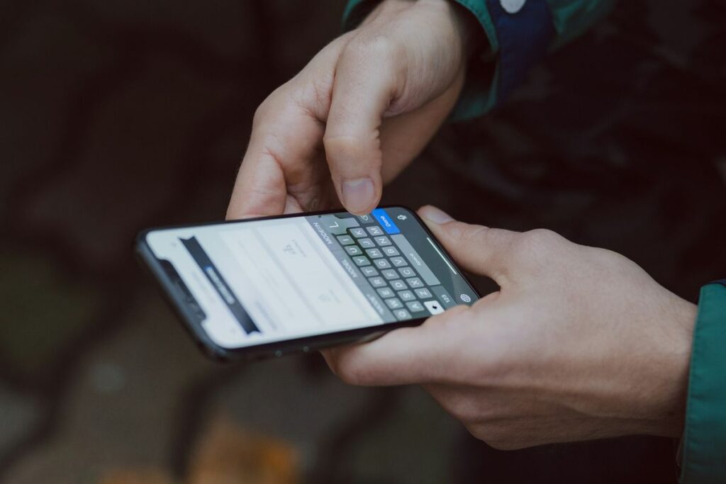 Manos escribiendo un mensaje en un teléfono móvil